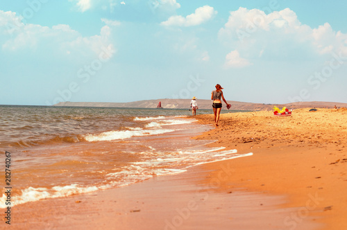 summer time young woman walking on empty beach - weather forecast