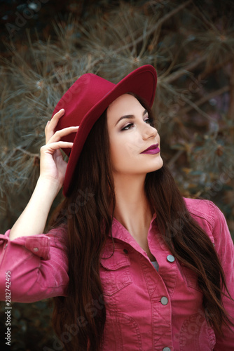 Beautiful woman wearing red hat and jacket outdoors