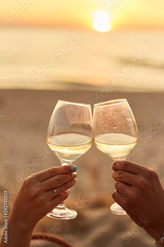Couple clinking glasses of champagne at sunset © Dima Anikin
