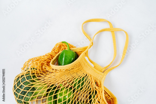 Products and Fresh vegetables in string mesh bag on a white background..Zero waste shopping concept. Recycling. Awareness consumption. Sustainable lifestyle.