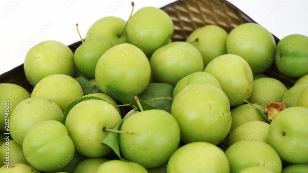 green plums on white ground, fresh plums, sour plums in a container, green and sour plums, green plums on white ground, fresh plums, sour plums in a container, green and sour plums,
