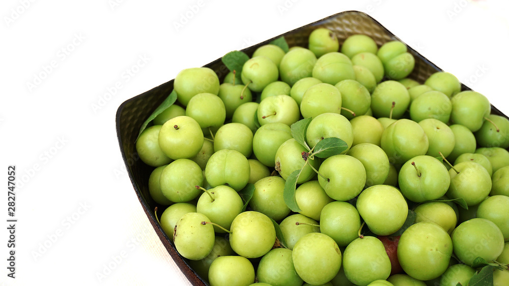 sour plums in a container, green and sour plums,