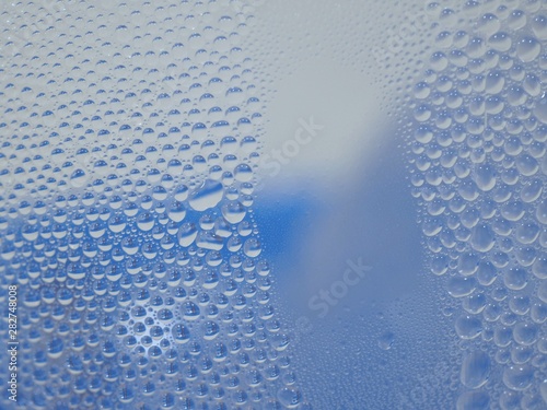 Water droplets surface on clear glass  In blue and white tones
