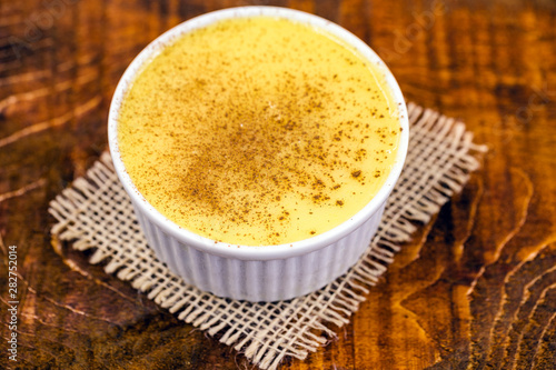 Dessert of curau. Brazilian sweet corn  corn mousse with cinnamon on a wooden background. Typical Brazilian dessert  sweet of June party. Dessert  canjica or Jimbel  .