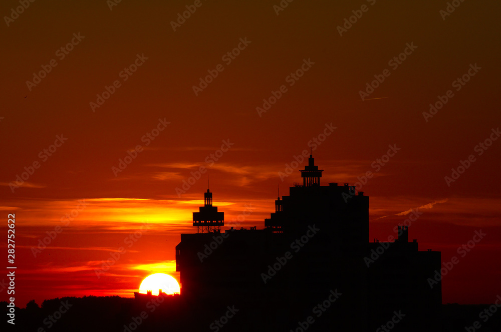 Sunset over the city, sun at horizon, building silhouette. Vitebsk, Belarus, June 2019