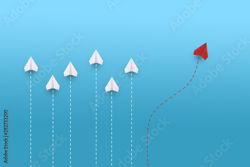 Creative paper planes on blue background. Leadership and success concept.group of white paper planes in one direction and one red paper plane pointing in different way.