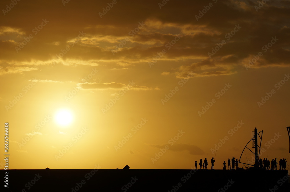 Naklejka premium Angler am Pier im Gegenlicht