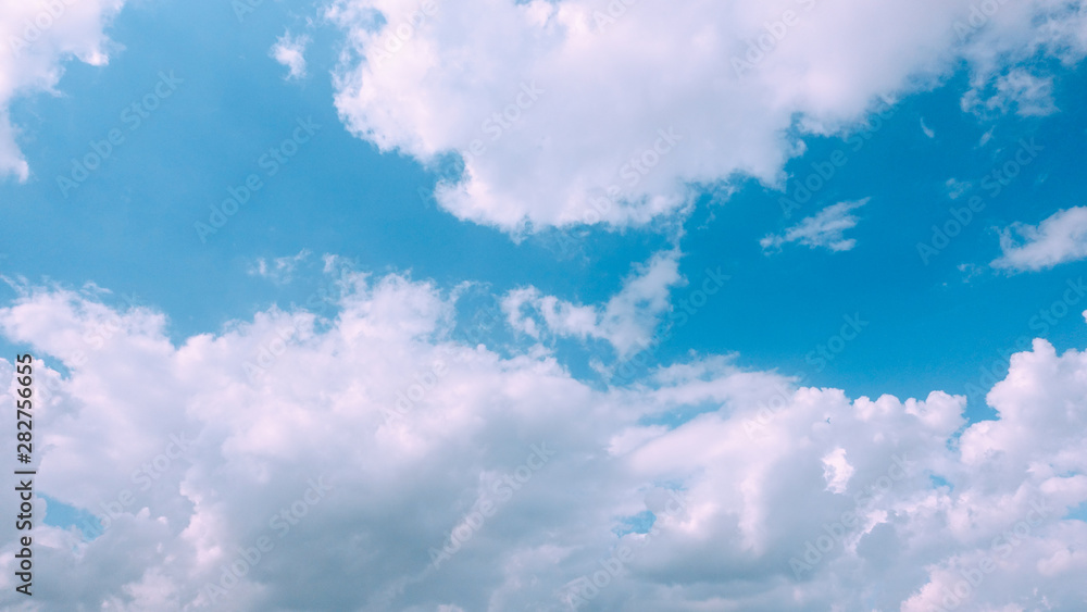 Beautiful bright blue sky with white fluffy clouds on a clear sunny day. Royalty high-quality free stock photo image of blue sky with white cloud, nice weather. Photo of natural cloudscape background
