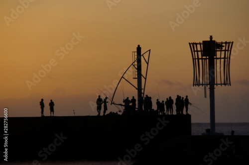 Angler am Pier im Gegenlicht