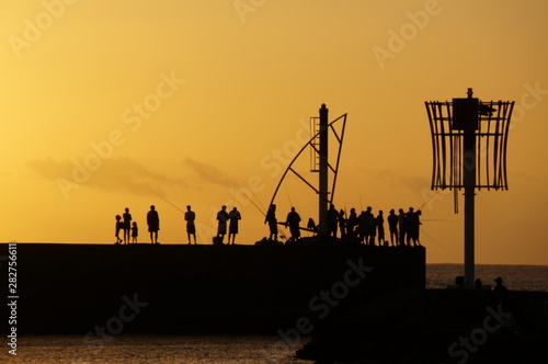 Angler am Pier im Gegenlicht