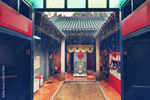 Tin Hau Temple Complex, Yau Ma Tei, Hong Kong. Small courtyard with open roof in the rain. Translation: signs in the center  - 