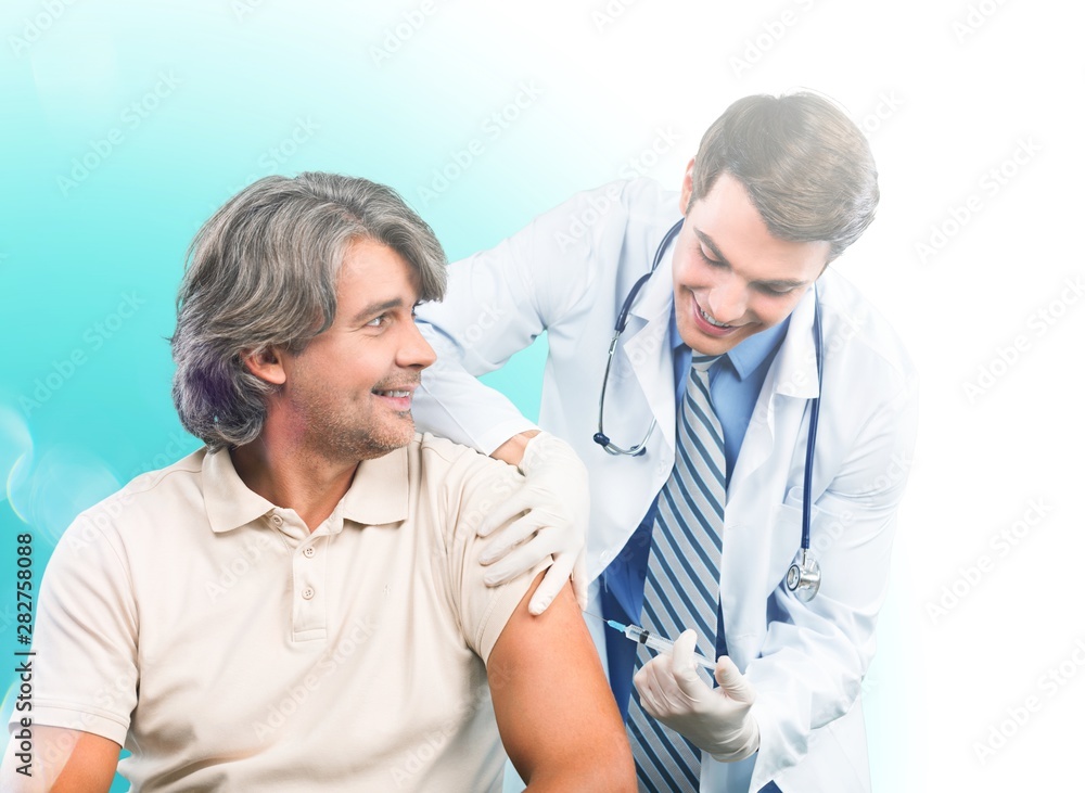 Handsome doctor making vaccination to male patient on background Handsome doctor making vaccination to male patient on background