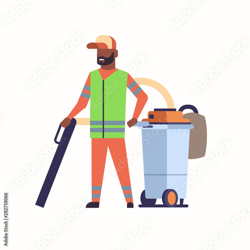 male street janitor using industrial vacuum cleaner african american man in uniform vacuuming garbage streets cleaning service concept full length flat white background