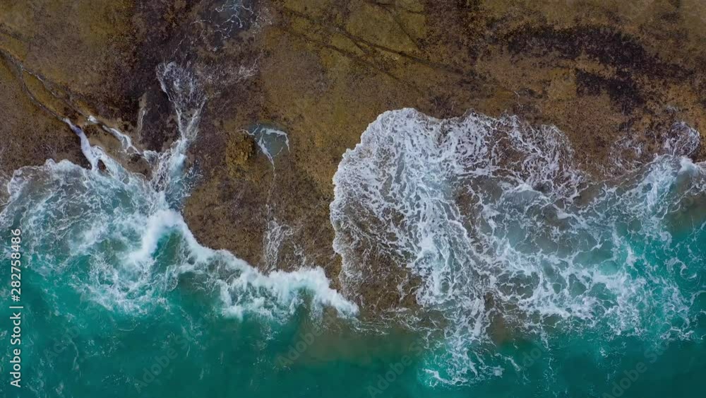 Top view of the desert stony coast on the Atlantic Ocean. Coast of the island of Tenerife. Aerial drone footage of sea waves reaching shore Top view of the desert stony coast on the Atlantic Ocean. Coast of the island of Tenerife. Aerial drone footage of sea waves reaching shore