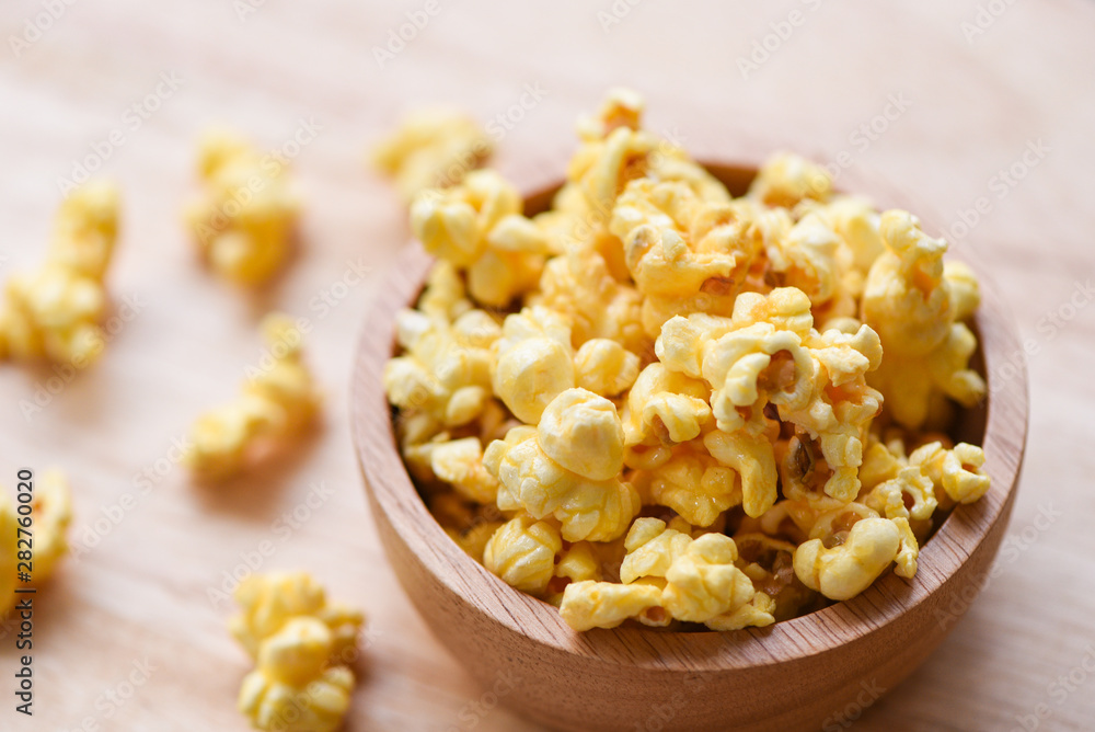 Sweet butter popcorn in bowl on wooden Sweet butter popcorn in bowl on wooden