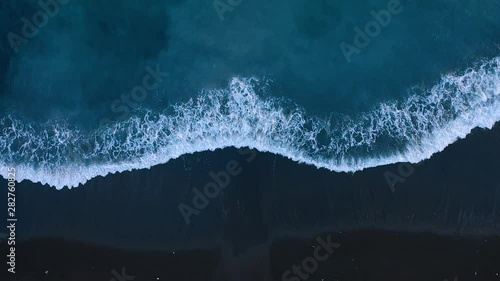 Top view of the desert black beach on the Atlantic Ocean. Coast of the island of Tenerife. Aerial drone footage of sea waves reaching shore photo