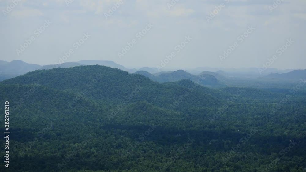 Rolling hills in the distance with dense forest and low clouds and fog in the valley between. Wide aerial landscape view of rural mountain scenery. Rolling hills in the distance with dense forest and low clouds and fog in the valley between. Wide aerial landscape view of rural mountain scenery.