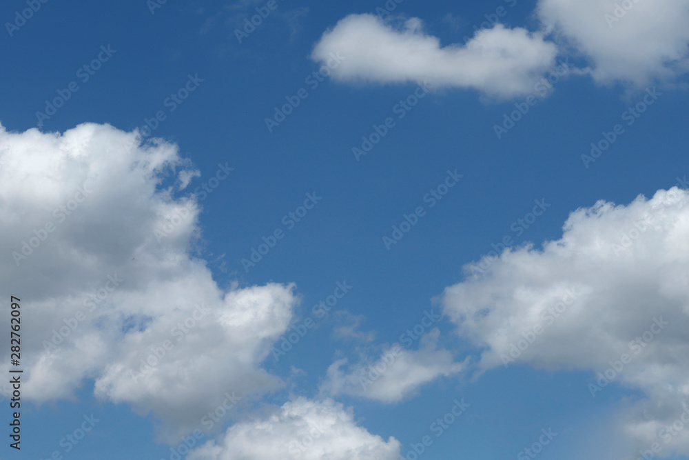 Background of blue sky with white fluffy clouds. Cropped shot, horizontal, outdoors, nobody. Concept of nature and ecology.