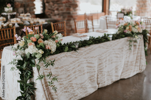 Flowers and Garland on Table at wedding reception, Greenery and florals wedding decor, modern and trendy 