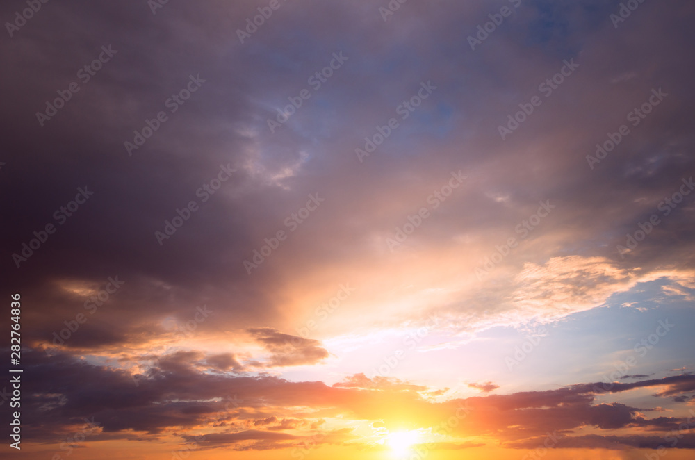 Bright sunset with rays on the background of thunderclouds.
