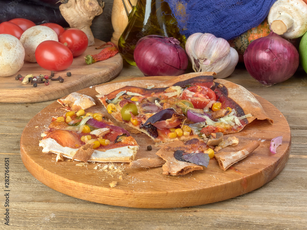 Pizza on thin dough.With slices of salami and ham ,olives and tomatoes. Pizza on thin dough.With slices of salami and ham ,olives and tomatoes.