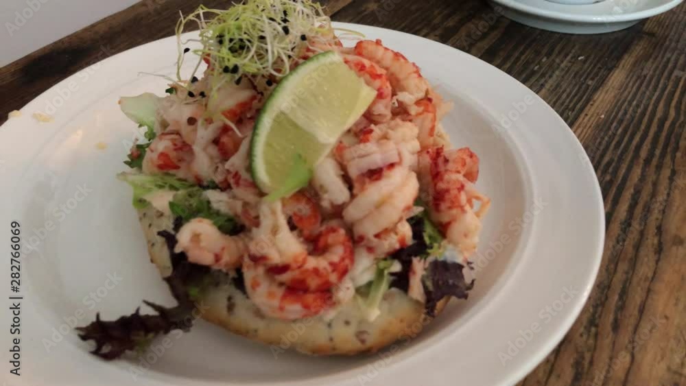 pan of an fresh sourdough sandwish with shrimps crayfish and a slice of lime pan of an fresh sourdough sandwish with shrimps crayfish and a slice of lime