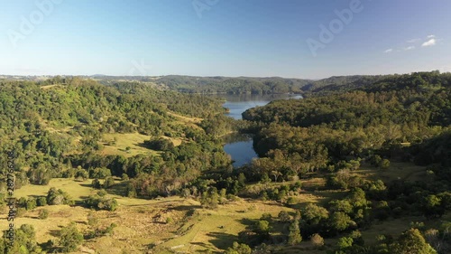 Aerial shot of a lake reservoir of water with forest surrounding it at sunrise in Queensland, Australia. Water consumption, global warming and severe drought affect the water level and reserve. photo