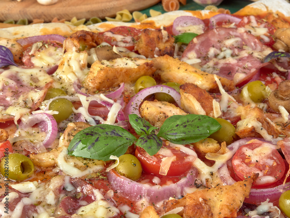 Pizza on thin dough.With slices of salami and ham ,olives and tomatoes. Pizza on thin dough.With slices of salami and ham ,olives and tomatoes.