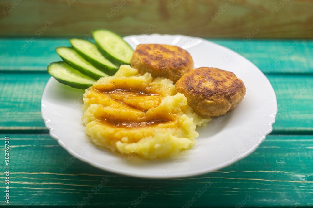 Mashed potatoes with cutlets and cucumbers.