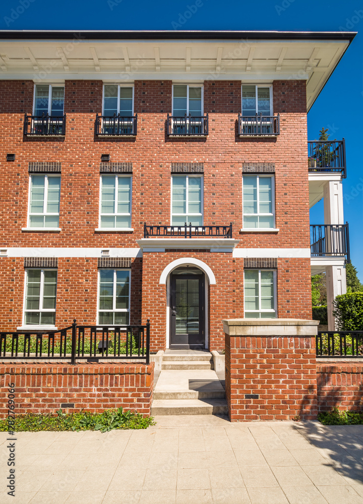 Brand new apartment building with entrance door on sunny day