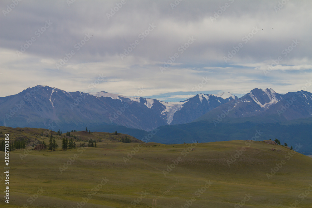 Snow tops in Altai mountains. Steppe valley. Summer travel concept.