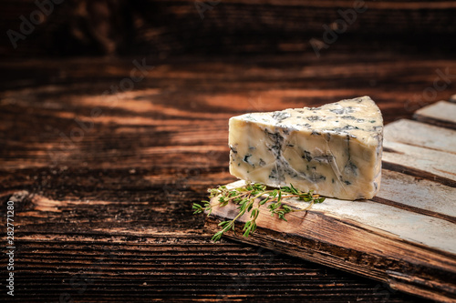 Canvas Print Blue cheese close up on an old wooden table