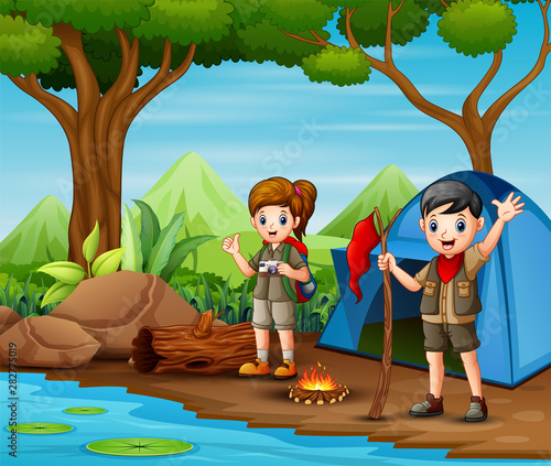 Scout boy and girl in uniform exploring the forest
