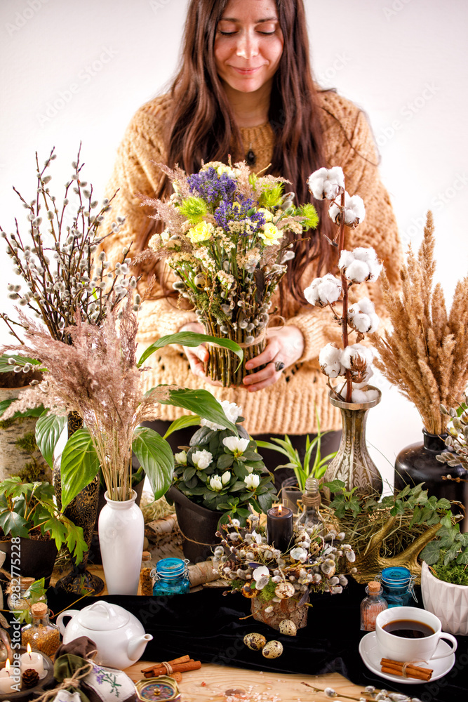 Still life with dry flowers and willow branches on a wooden table. Decor. decorations, dry branches of willow and a girl on the background. The concept of a traditional Russian holiday Palm Sunday. Still life with dry flowers and willow branches on a wooden table. Decor. decorations, dry branches of willow and a girl on the background. The concept of a traditional Russian holiday Palm Sunday.