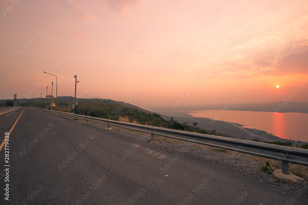 Fototapeta premium panoramic natural background of the evening's natural scenery (mountains, rivers, grasslands, roads, sunshine from the sun) is blurred through the cool, often seen in scenic spots or attractions while