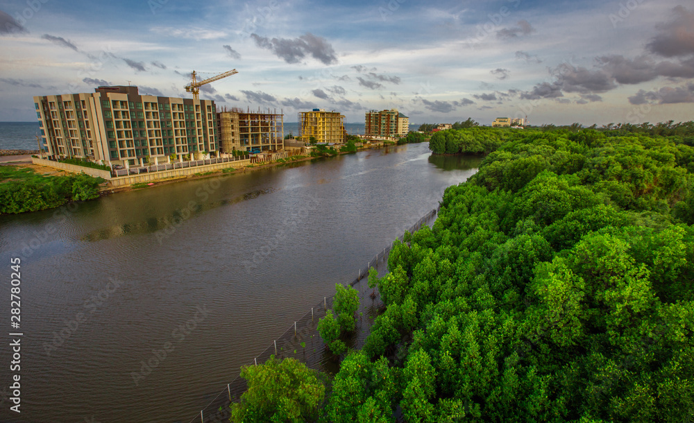 The natural background of the sky is blurred from the twilight light in the evening. There are a variety of colors, trees (mangroves, rivers, waterfront communities), complementary living
