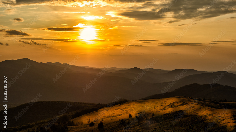 Stunning sunset in the mountains. Orange sky and mountains silhouettes. Carpathian Mountains. Bieszczady. Poland