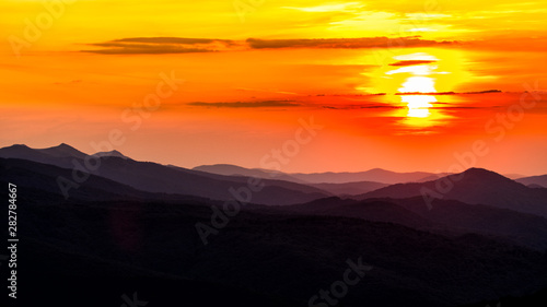 Stunning sunset in the mountains. Orange sky and mountains silhouettes. Carpathian Mountains. Bieszczady. Poland