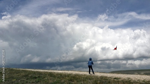 Boy launches a kite. Kite flying and storm clouds.