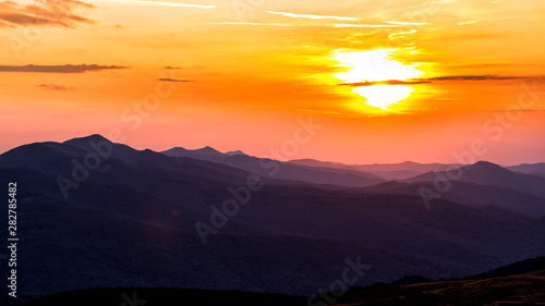 Fototapeta Naklejka Na Ścianę i Meble -  Stunning sunset in the mountains. Orange sky and mountains silhouettes. Carpathian Mountains. Bieszczady. Poland