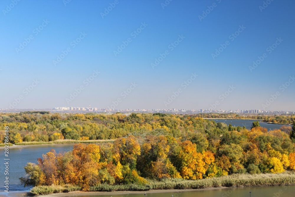 View of the river in autumn, yellow trees on the banks of the river.
