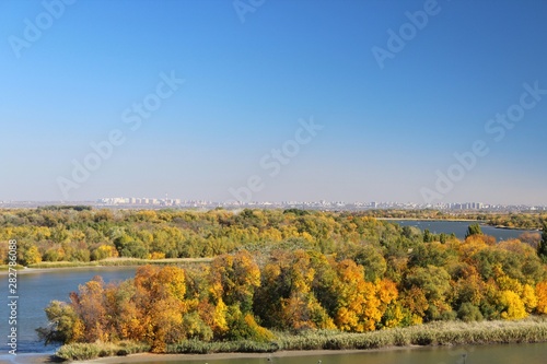 View of the river in autumn, yellow trees on the banks of the river.