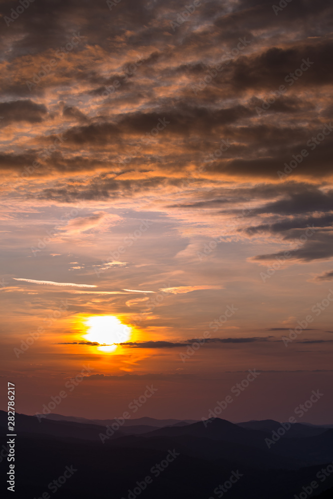 Stunning sunset in the mountains. Orange sky and mountains silhouettes. Carpathian Mountains. Bieszczady. Poland