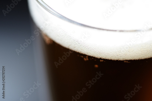 Glass of light beer close-up on a dark background