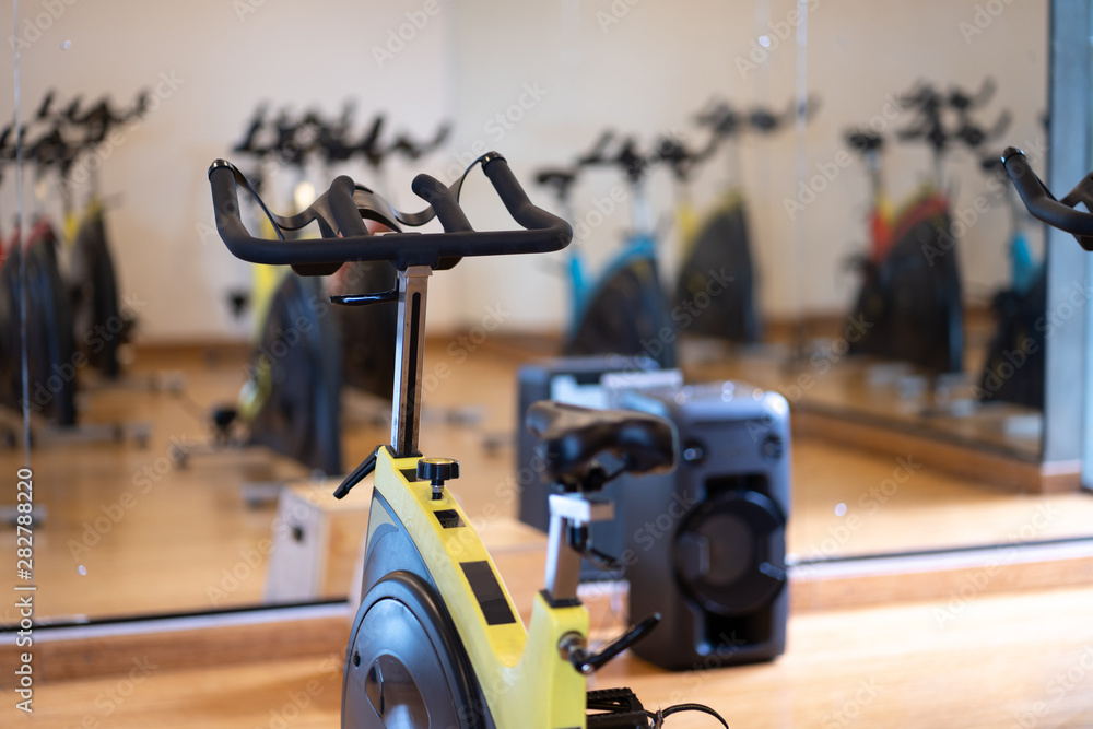 spinning exercise bikes gym room with many in a row