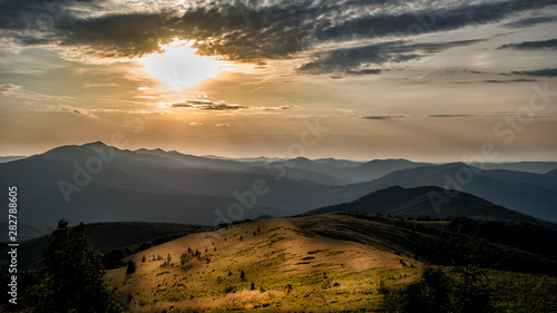 Stunning sunset in the mountains. Orange sky and mountains silhouettes. Carpathian Mountains. Bieszczady. Poland