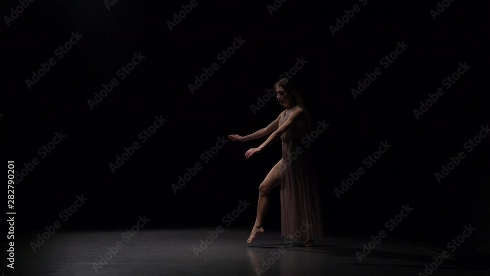 Slow motion of sporty maiden dancing contemp in dark studio. Slow motion of sporty maiden dancing contemp in dark studio.