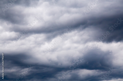 Dramatyczne niebo w tle. Stormy Clouds in Dark Sky. Moody Cloudscape. Obraz panoramiczny może być używany jako baner internetowy lub nagłówek strony. Zdjęcie stonowane i przefiltrowane z miejsca kopiowania.