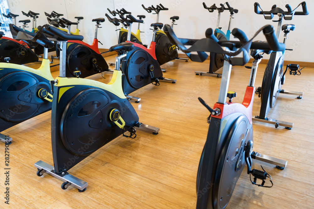 spinning exercise bikes gym room with many in a row