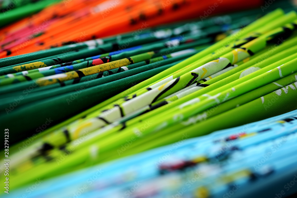 Set of folded multi-colored Vietnamese fans on a dark background close-up Set of folded multi-colored Vietnamese fans on a dark background close-up